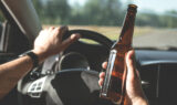 Man driving with open beer bottle